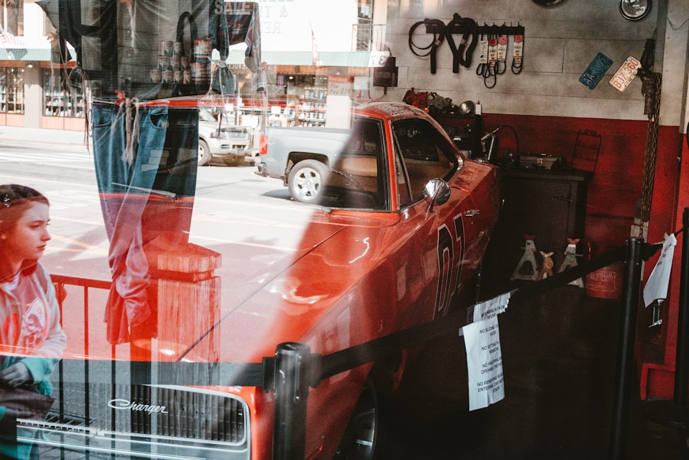 a red car parked in front of a store window