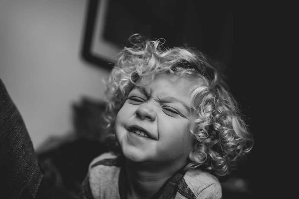 a little girl crying while sitting on a couch