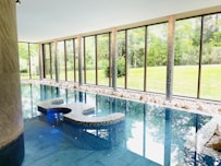 a large indoor swimming pool with a bench next to it