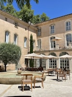 a courtyard with tables, chairs, and umbrellas