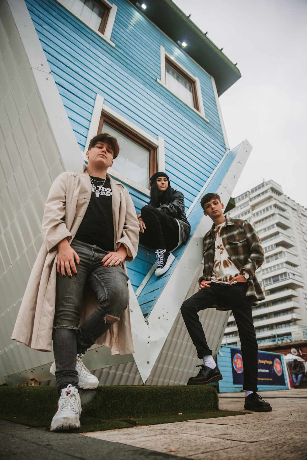 a group of young men sitting on the side of a building