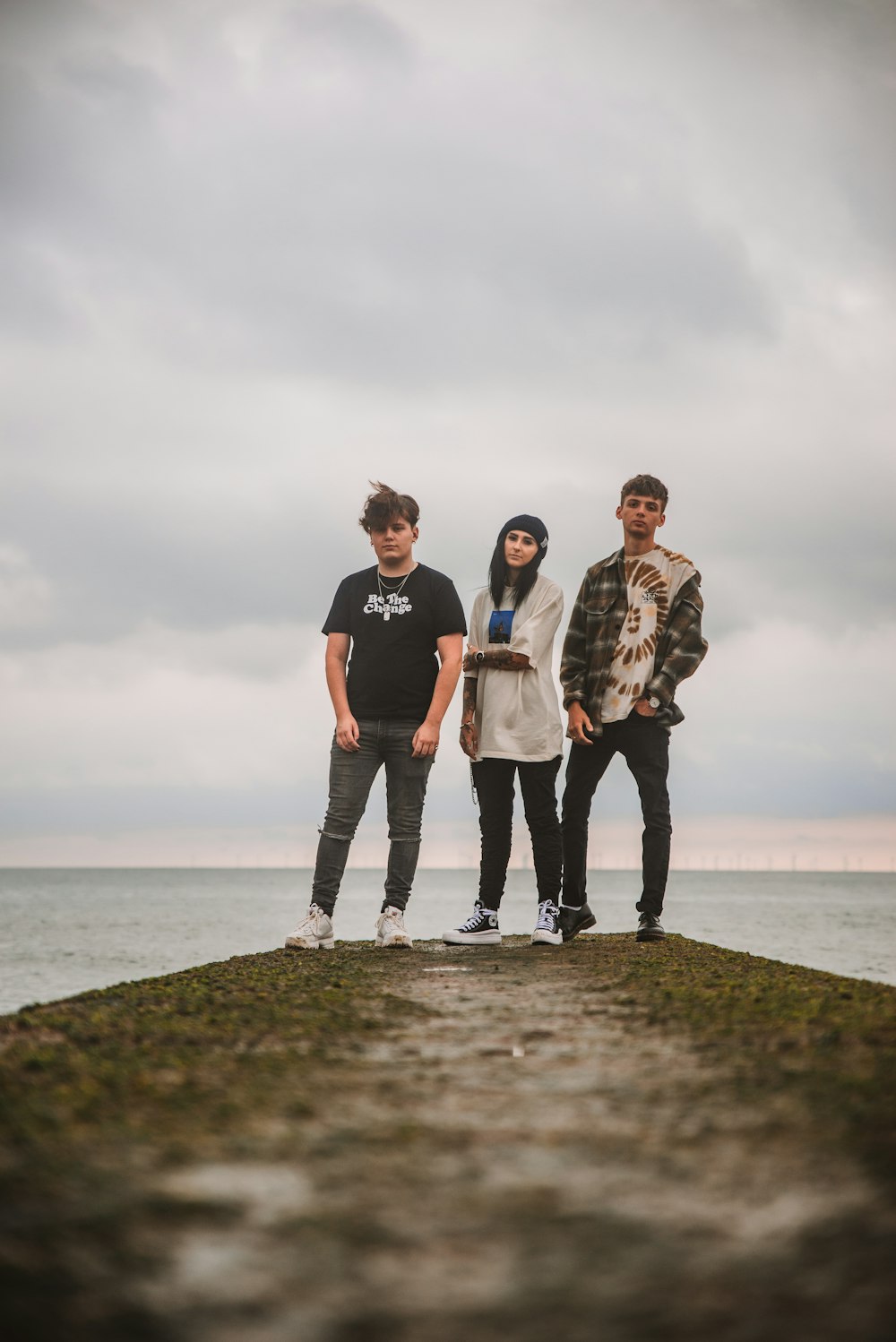 a group of three people standing on top of a rock