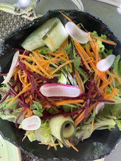 A vibrant green salad with fresh vegetables and a light dressing.