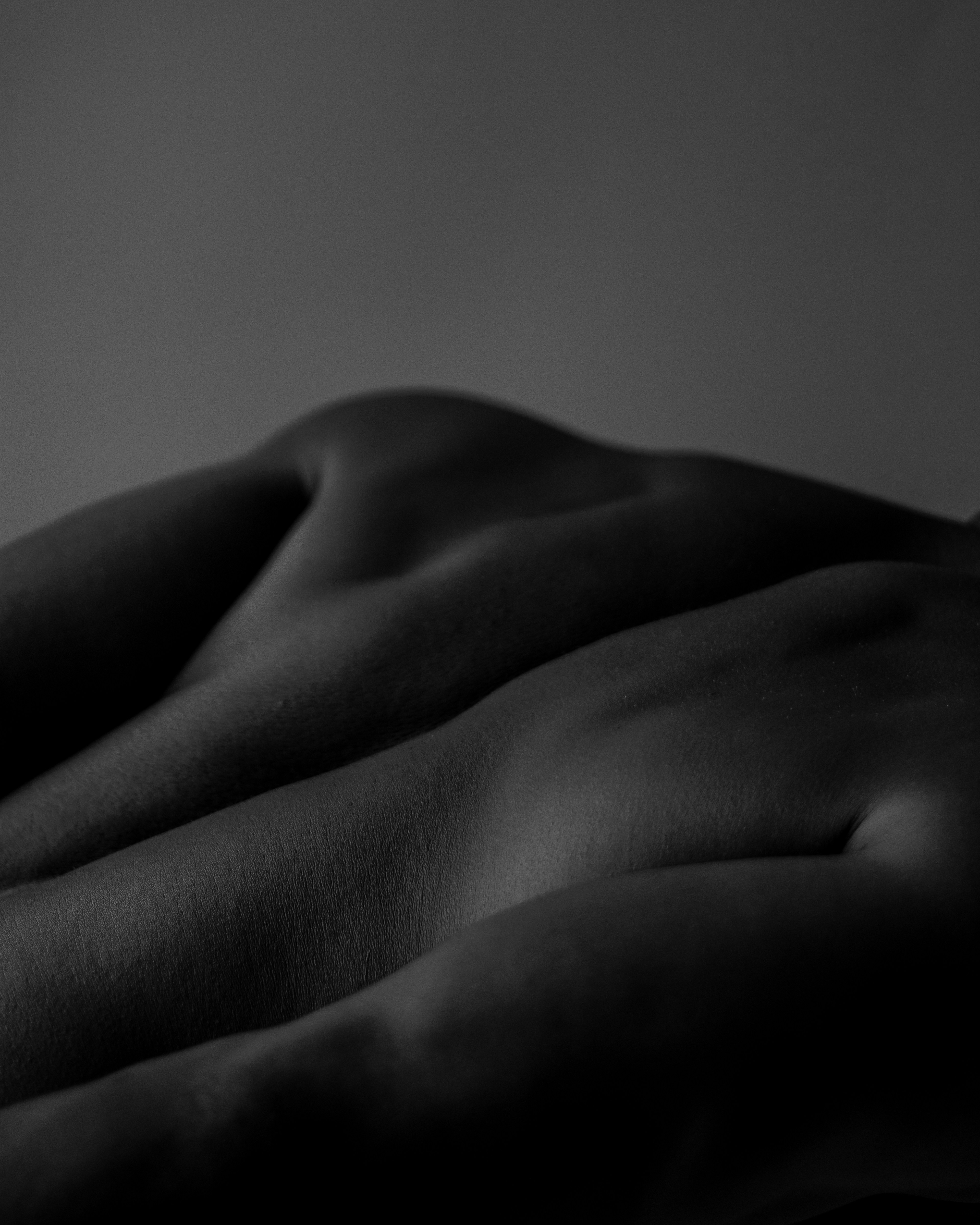 a naked woman laying on a bed in a dark room