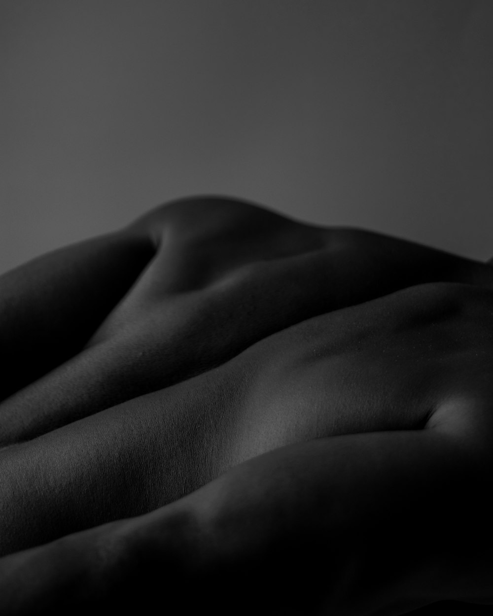 a naked woman laying on a bed in a dark room