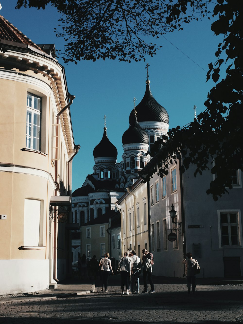 a group of people walking down a street next to tall buildings