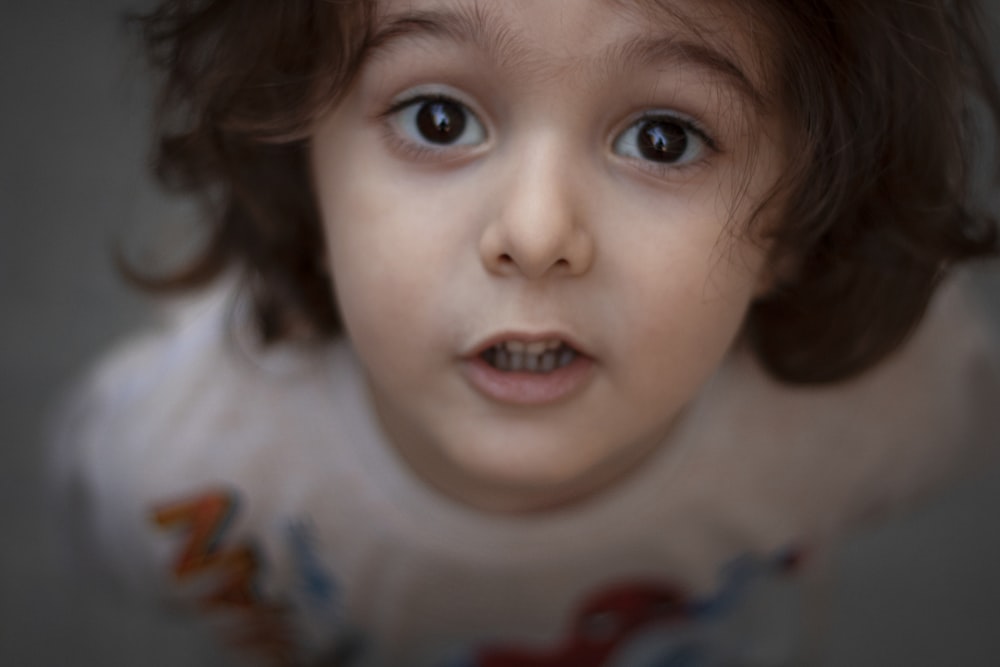 a close up of a child's face with blue eyes