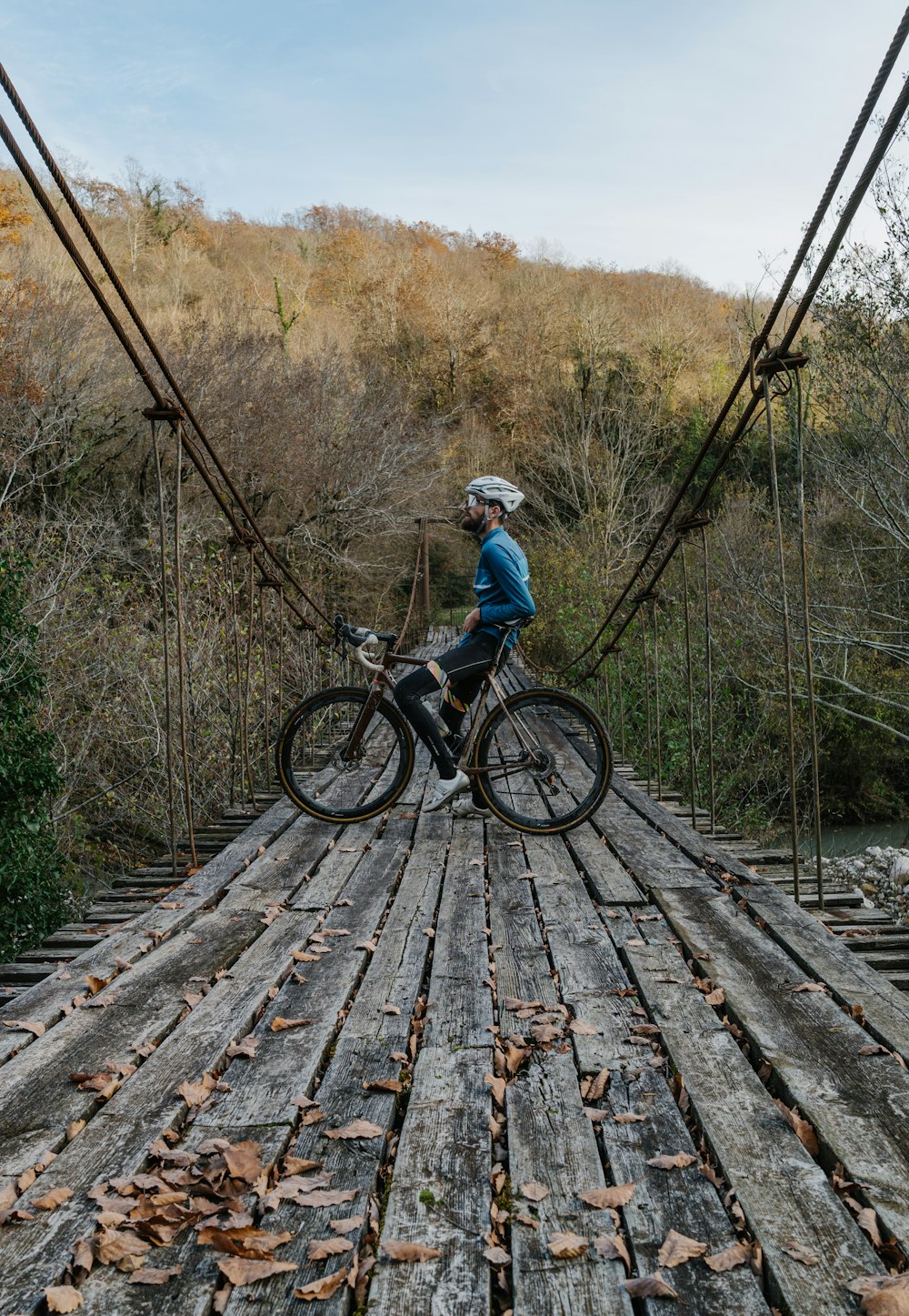 Un hombre montando en bicicleta a través de un puente de madera