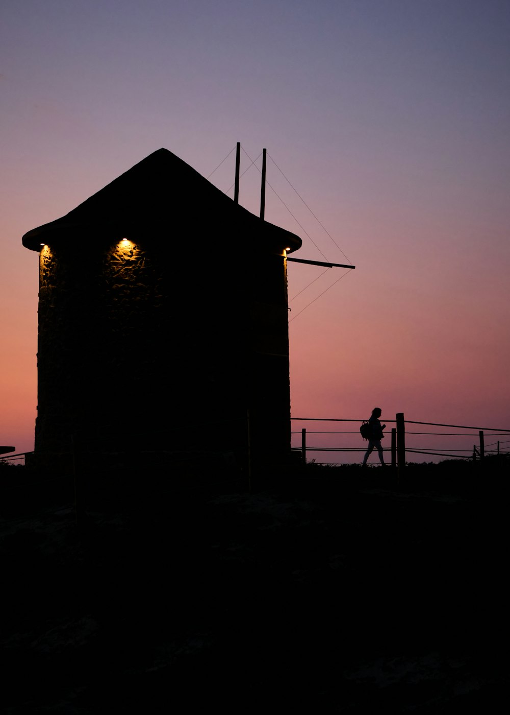 a silhouette of a person standing in front of a building