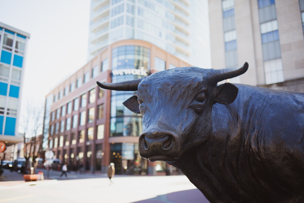a statue of a bull on a city street