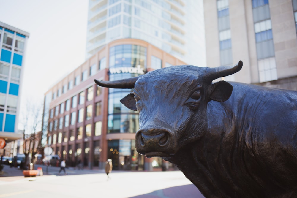 Una statua di un toro su una strada della città