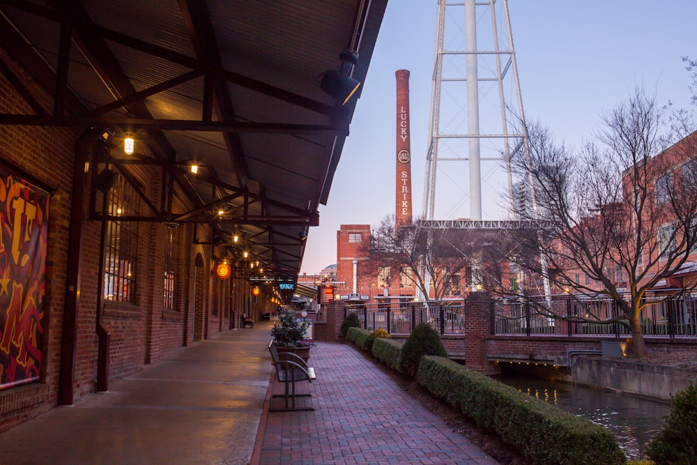 a brick walkway next to a building with a water tower in the background