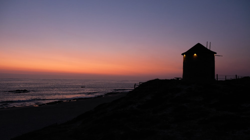 a small tower sitting on top of a hill next to the ocean