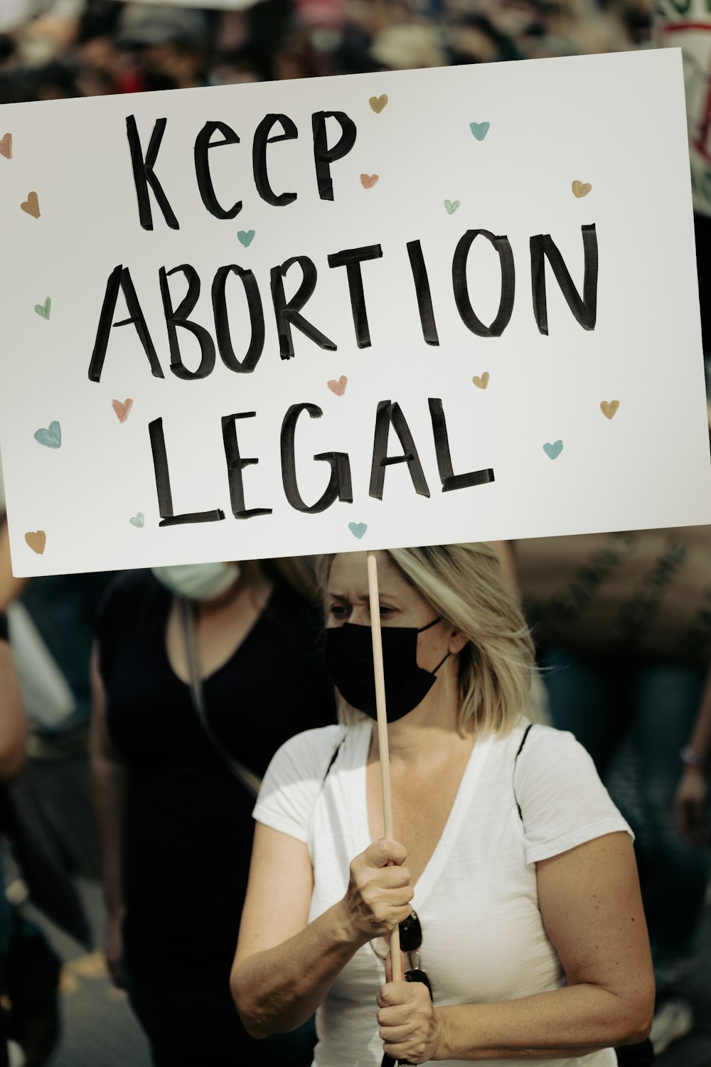 a woman holding a sign that says keep abortion legal