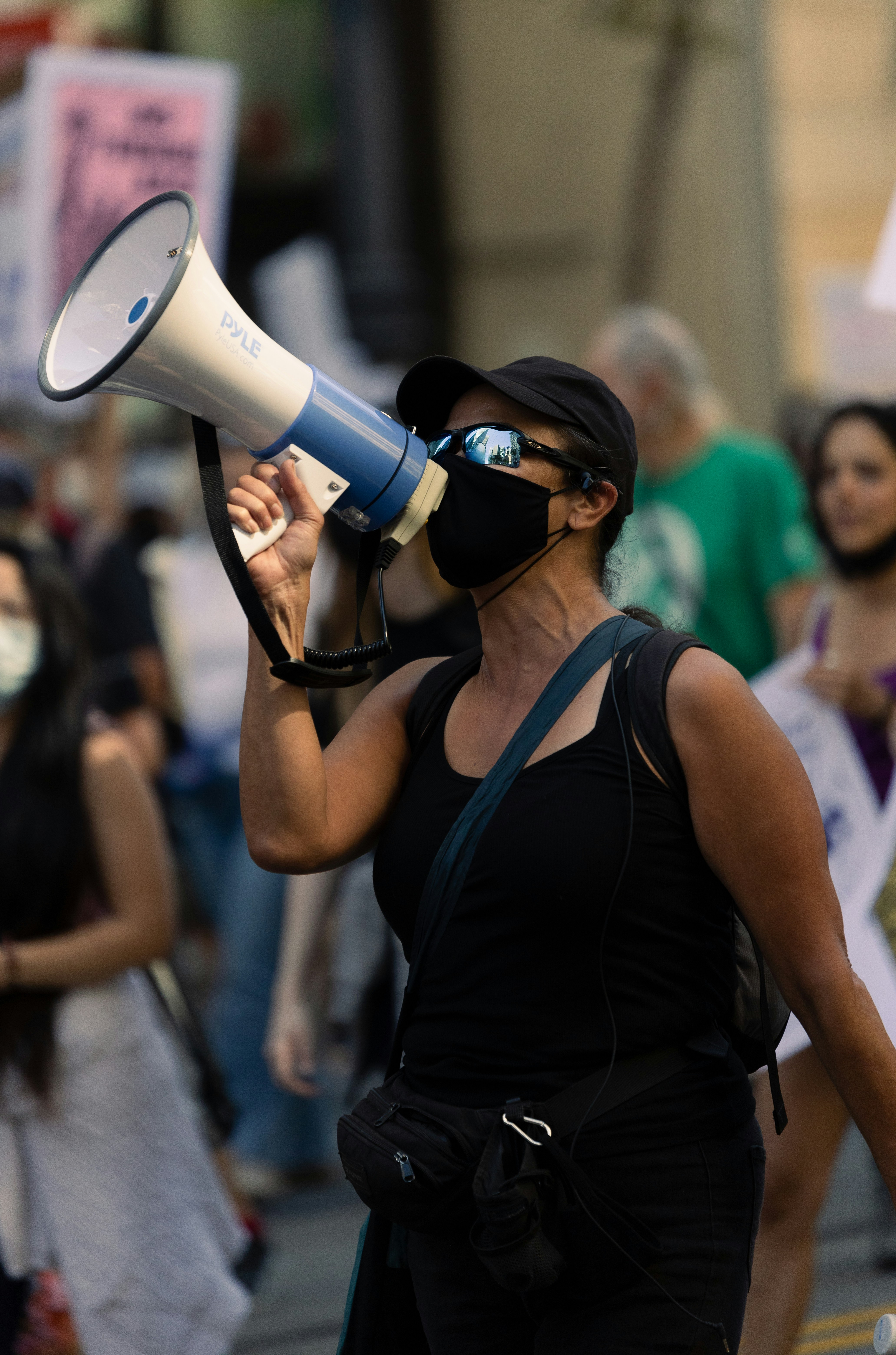 A woman wearing a face mask and holding a megaphone photo Free Ca