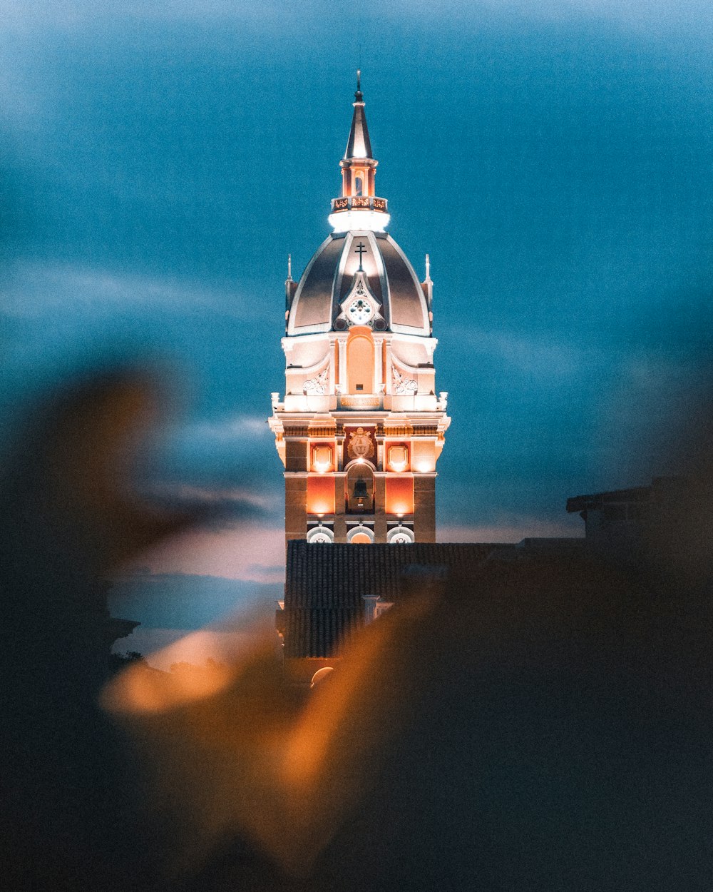 a clock tower lit up at night with a sky background