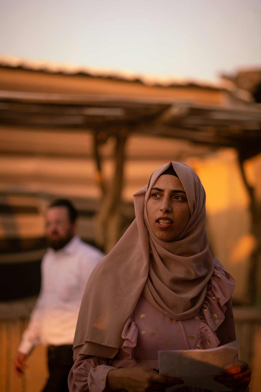 a woman in a hijab standing next to a man