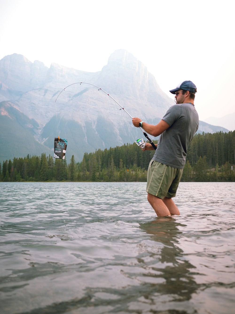 a man standing in the water while holding onto a kite