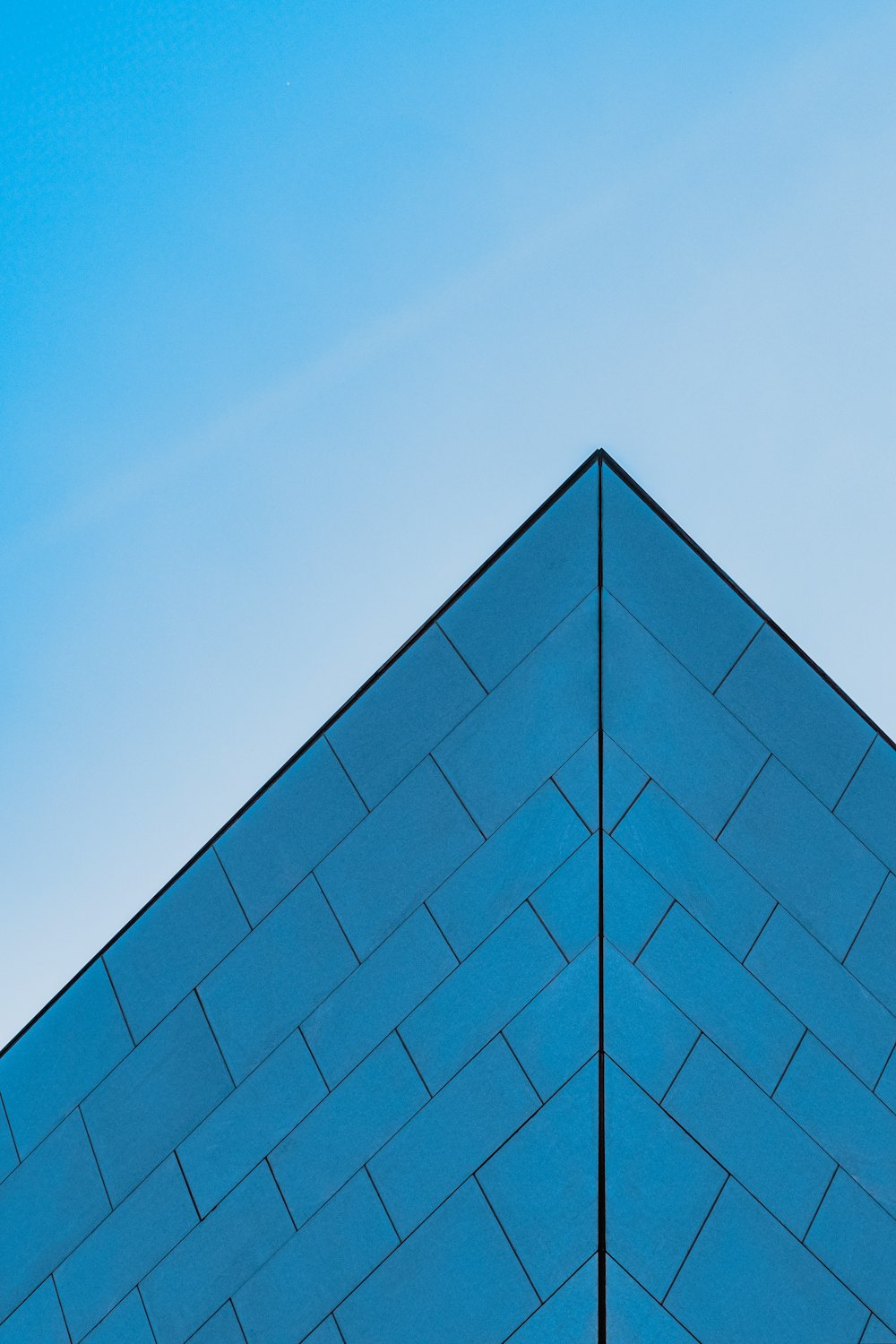 a blue building with a plane flying in the sky