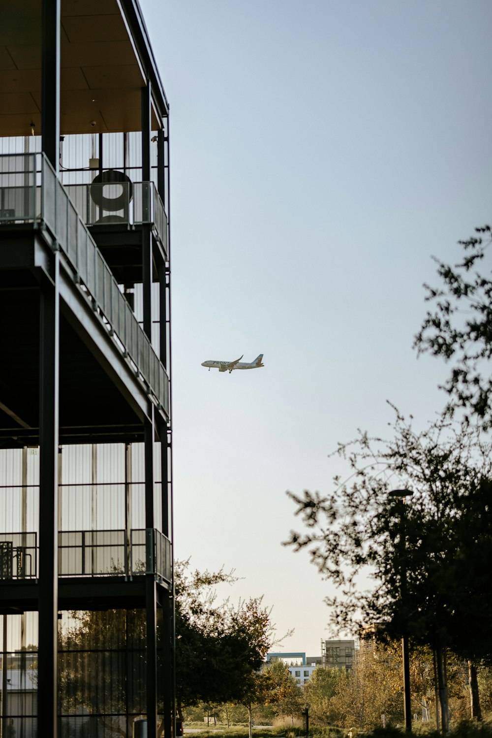 an airplane is flying over a building with balconies