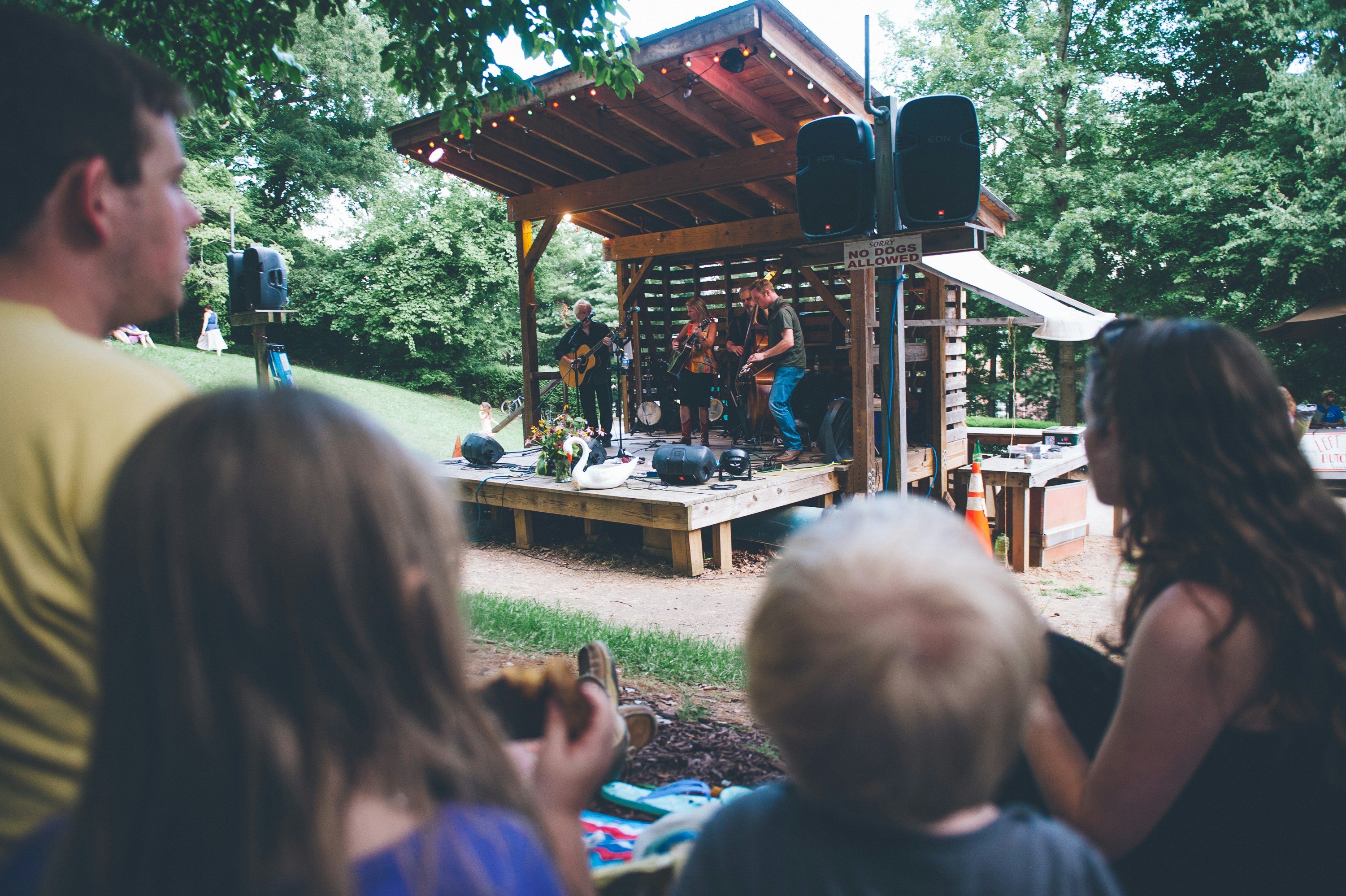 a group of people sitting in front of a wooden structure
