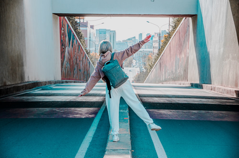 a woman standing in a tunnel with her arms outstretched