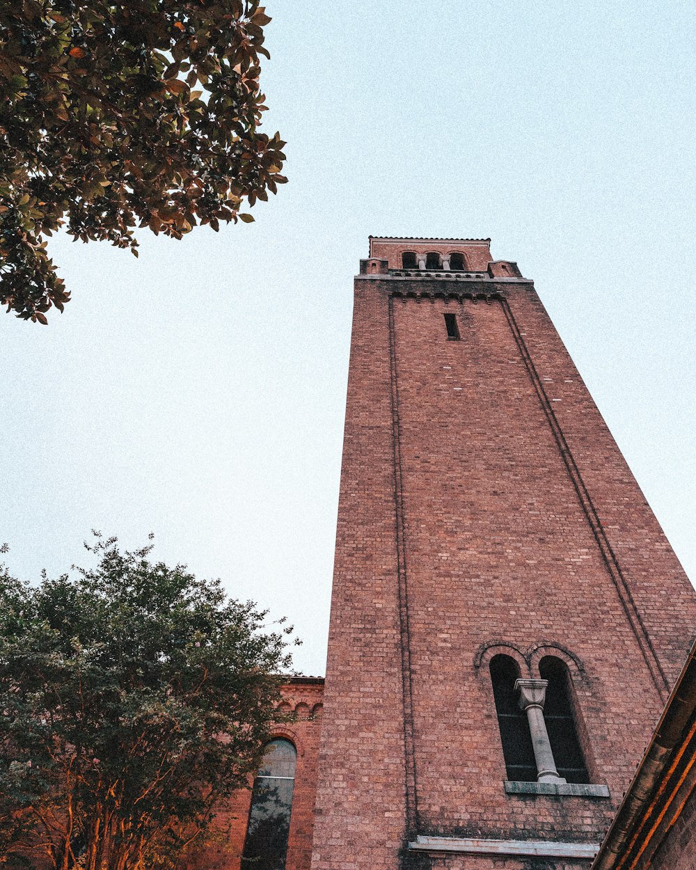a tall brick tower with a clock on it's side