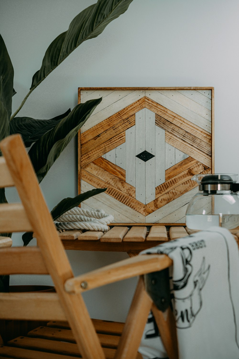 a wooden chair sitting next to a painting on a wall