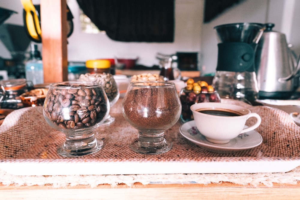 a table topped with two glasses filled with coffee