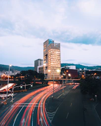 a city street filled with lots of traffic next to tall buildings