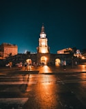 a clock tower lit up at night in a city