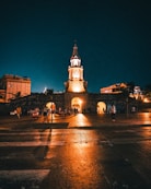 a clock tower lit up at night in a city
