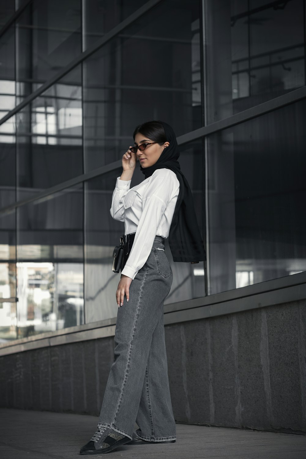 a woman standing on a sidewalk talking on a cell phone