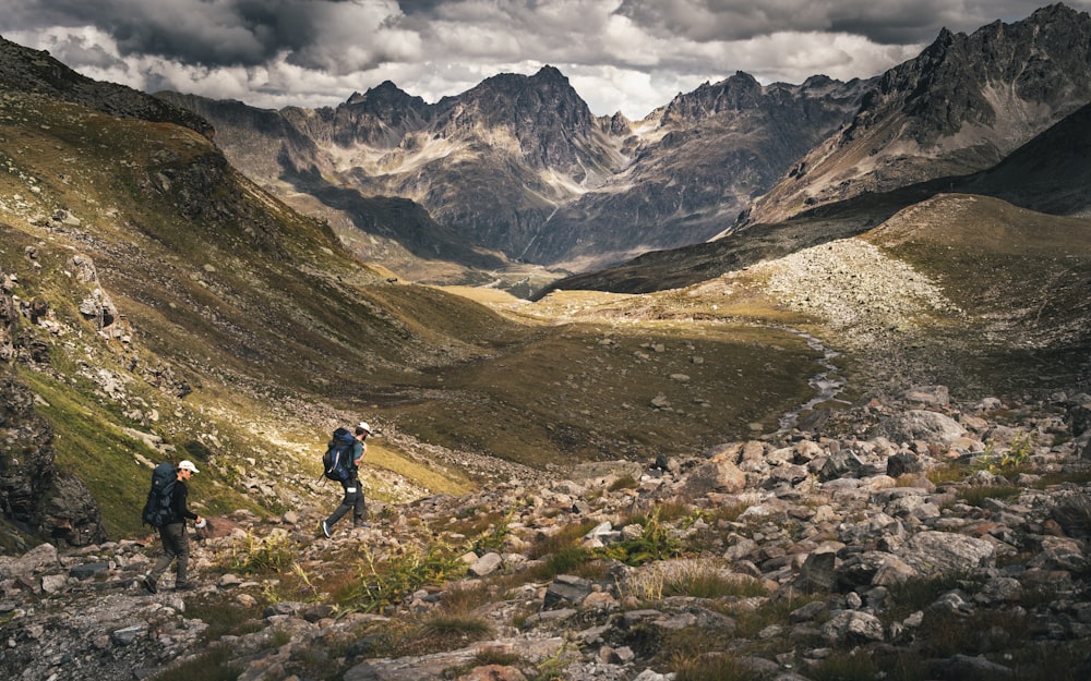 a couple of people hiking up a mountain