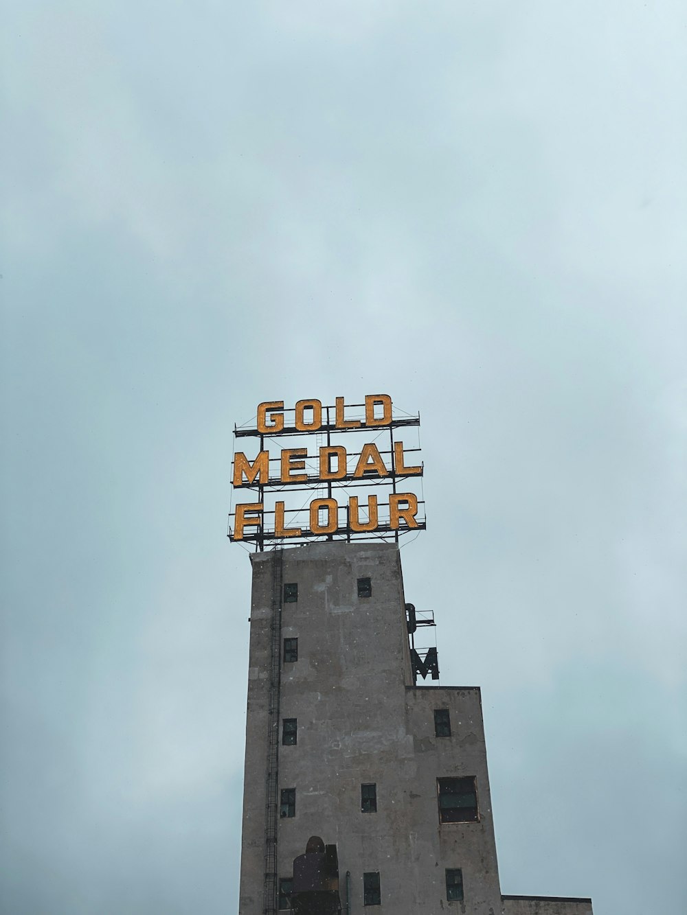 a tall building with a neon sign on top of it