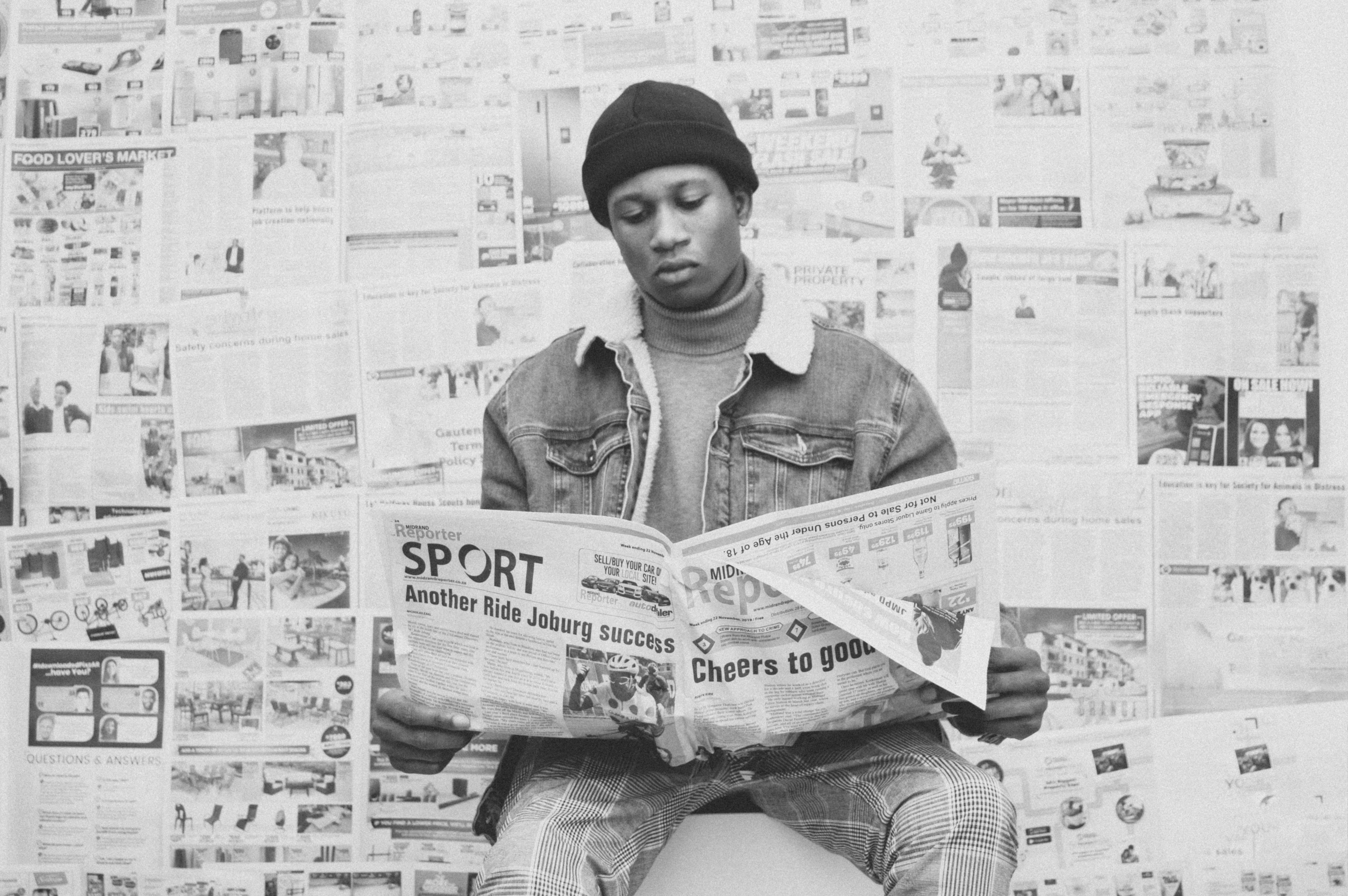 a man sitting on a toilet reading a newspaper