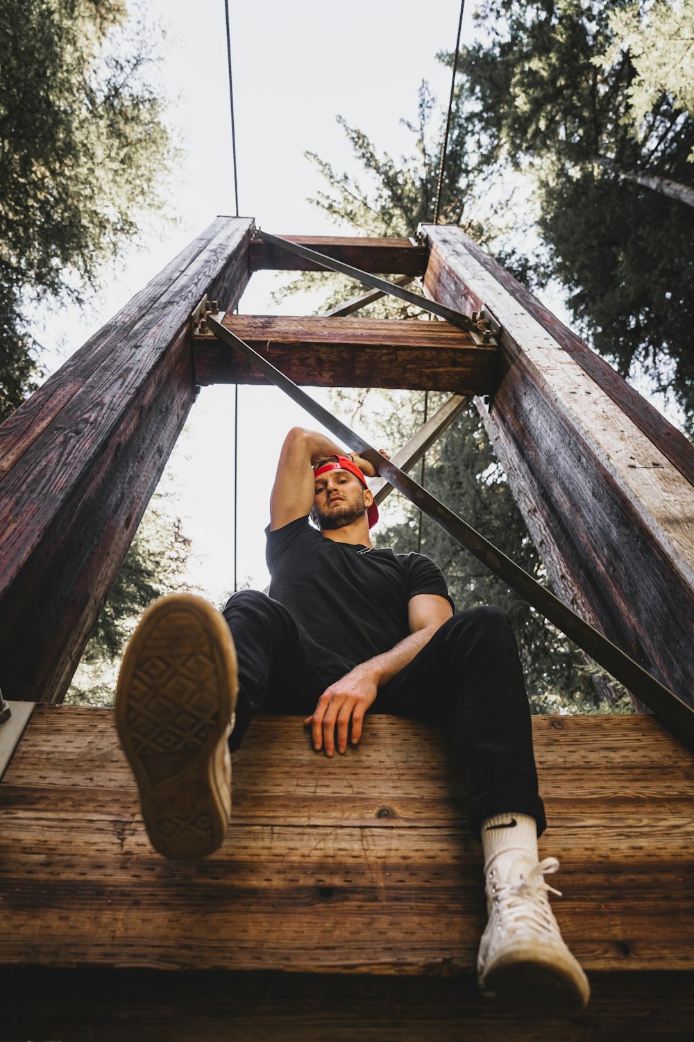 a man sitting on top of a wooden structure