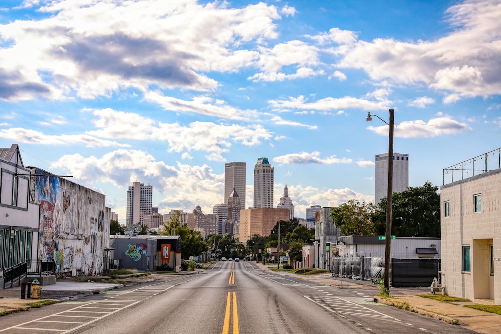 an empty street with a few buildings in the background