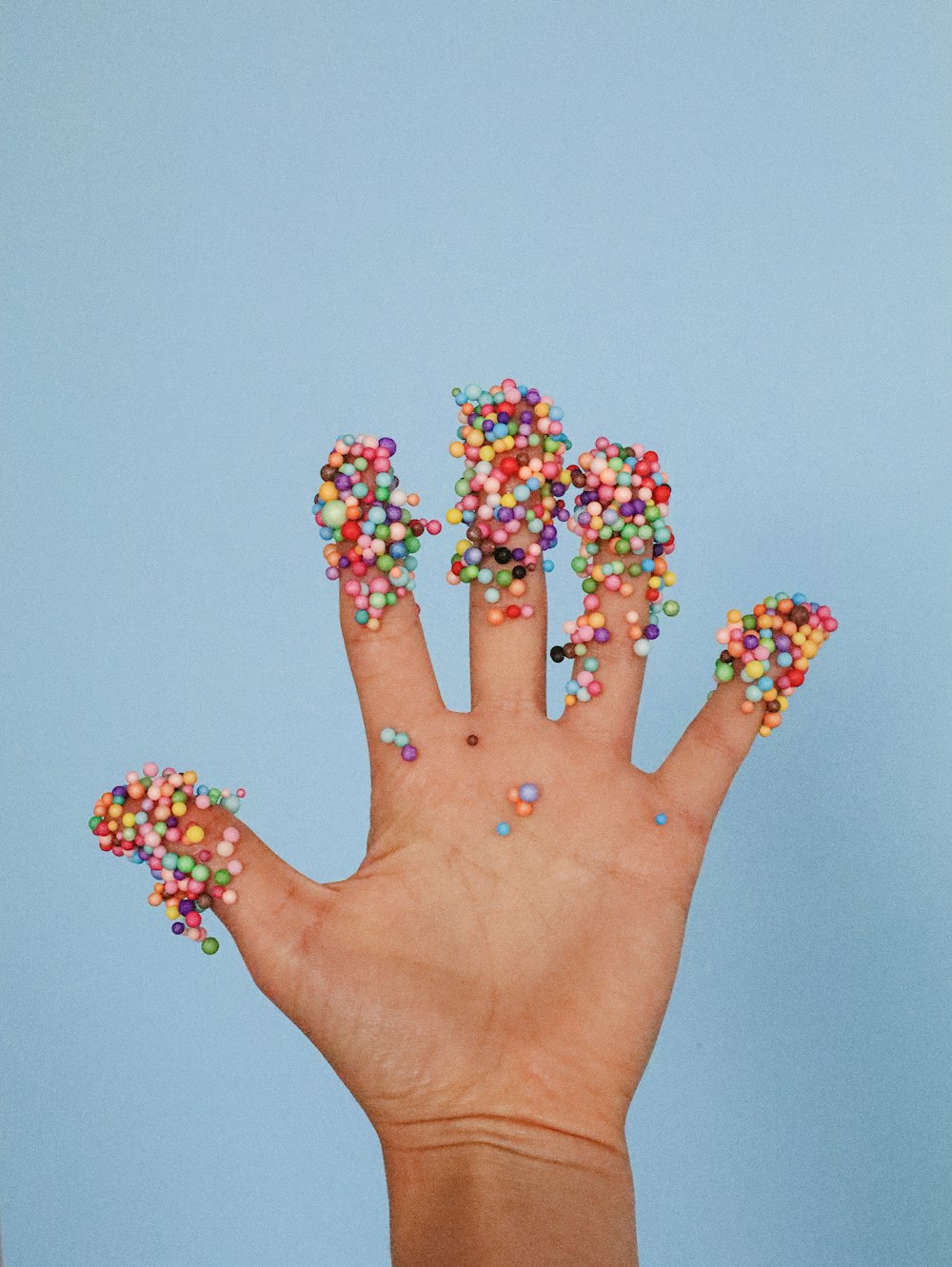 a person's hand with sprinkles on it