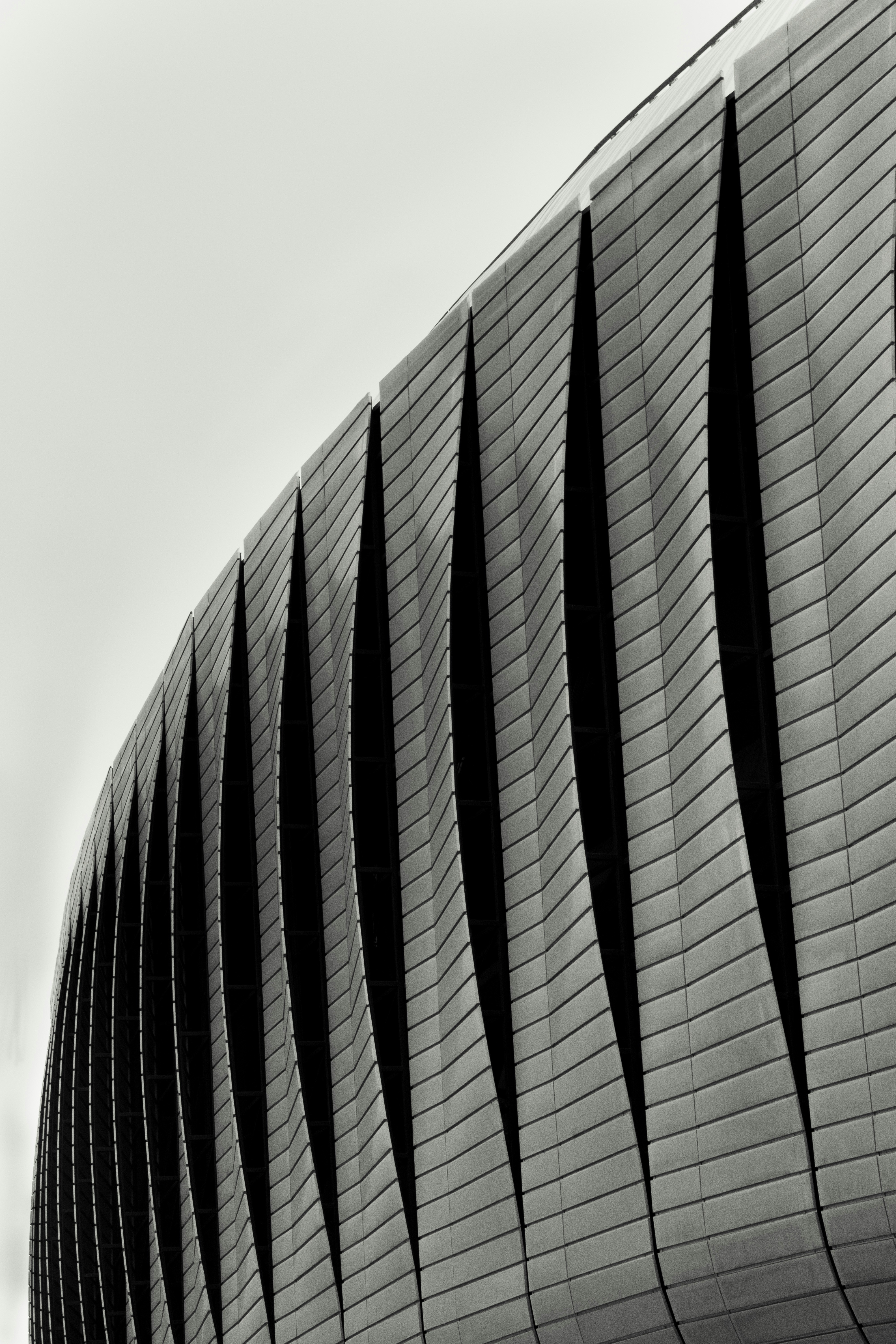a black and white photo of a curved building