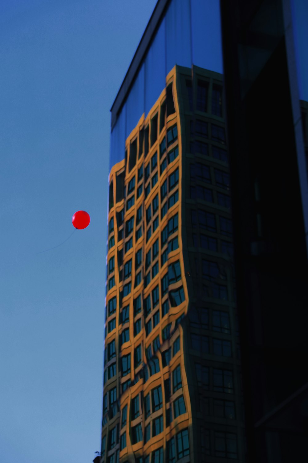 a red object flying in the air near a tall building