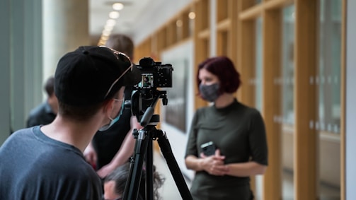 a man and a woman standing in front of a camera