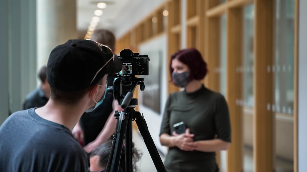 a man and a woman standing in front of a camera