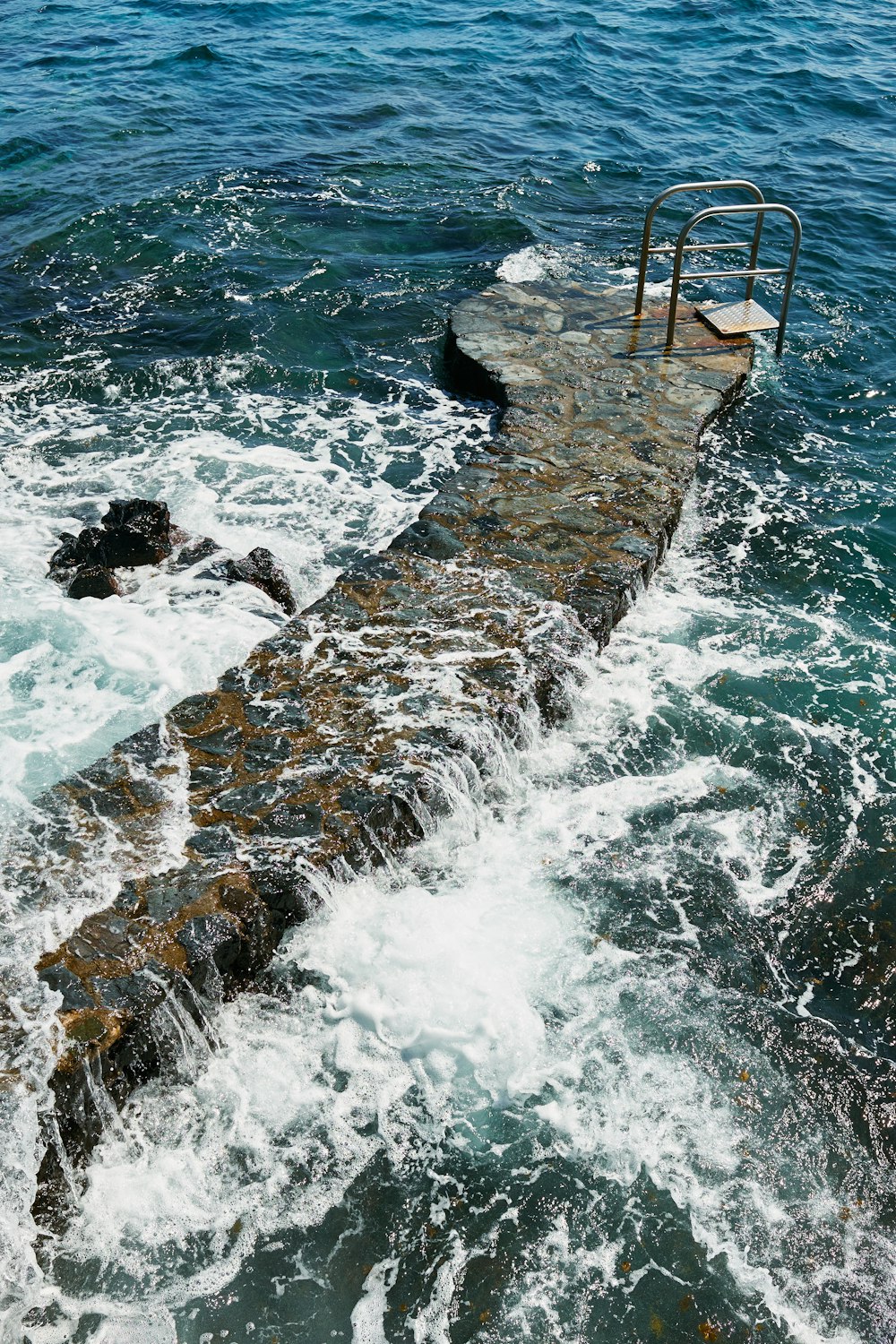 an old concrete dock in the middle of a body of water