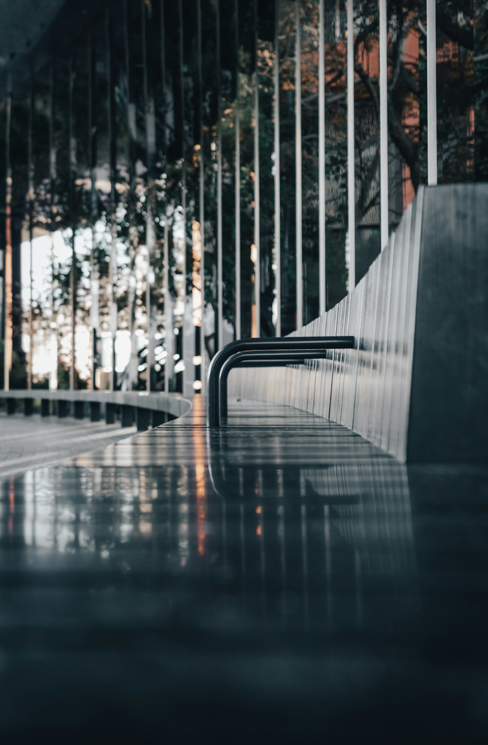 a bench sitting in front of a metal fence