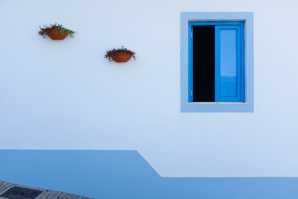 a white building with blue trim and three planters on the wall