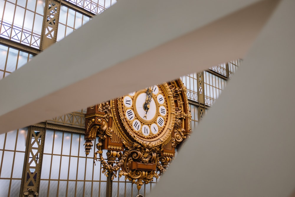 a gold clock hanging from the ceiling of a building