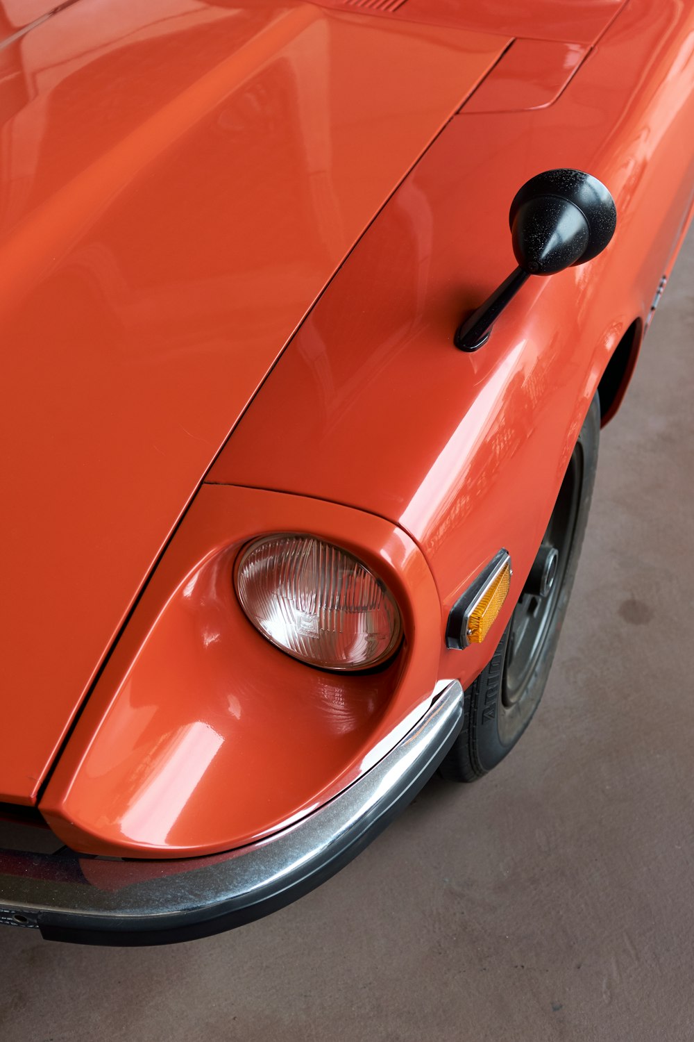 an orange sports car parked in a garage