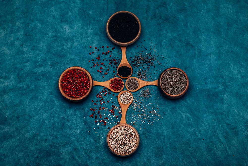 three wooden spoons filled with different types of spices