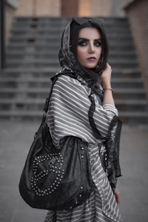 a woman in a black and white dress carrying a black purse